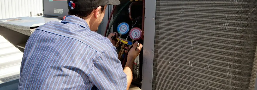 HVAC technician servicing a condenser unit in Del Rio