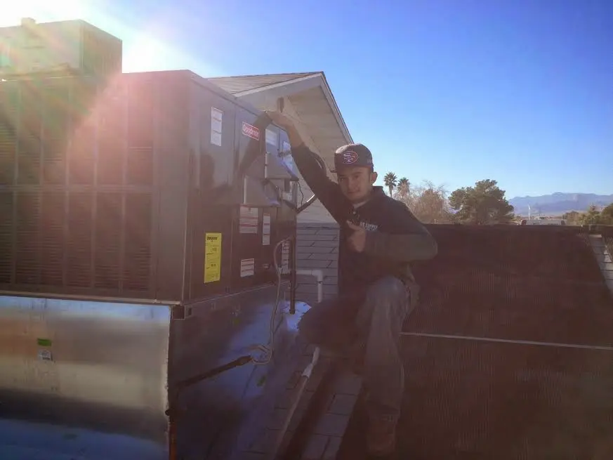 HVAC technician performing AC Tune-Up on a rooftop unit in Del Rio